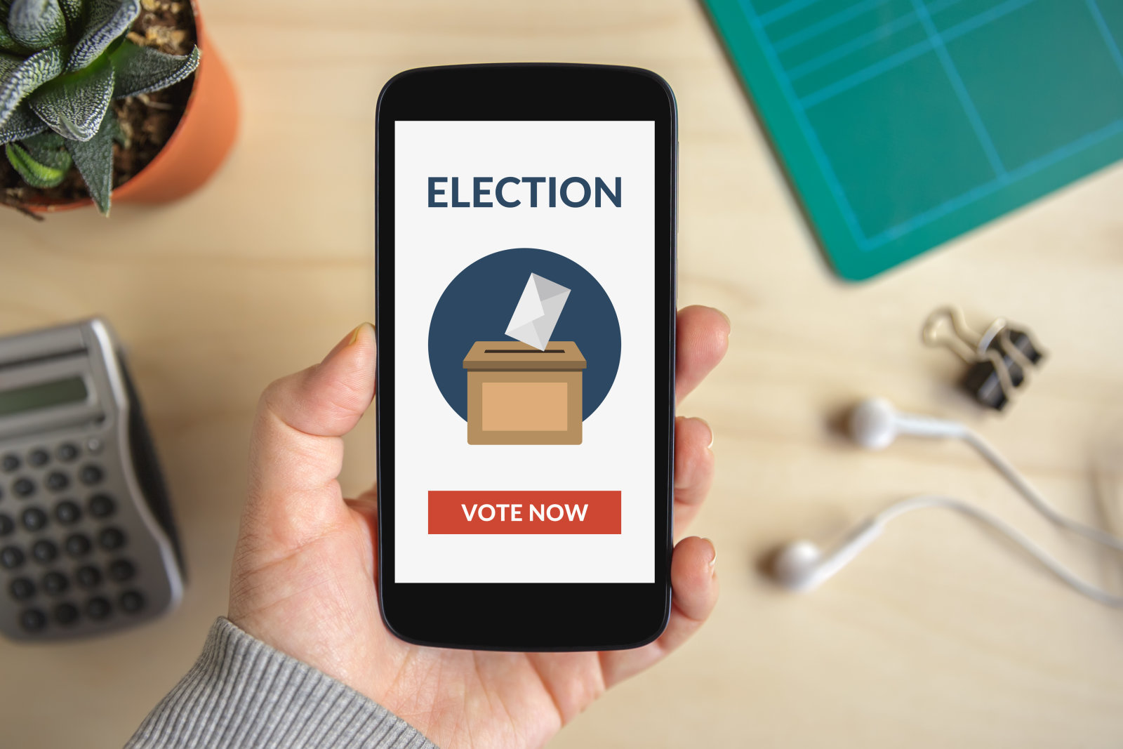 Hand holding smart phone with online voting concept on screen